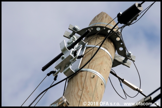 Nadzemní optická síť provedená závěsnými optickými kabely. Detail kotvení kabelů na sloupu.